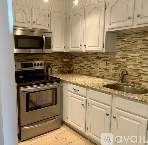A kitchen with white cabinets and a stainless steel oven.