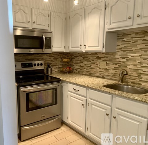 A kitchen with white cabinets and a stainless steel oven.