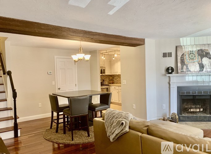 A living room with a fireplace and a dining table.
