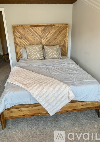 A bed with a wooden headboard and a striped blanket.