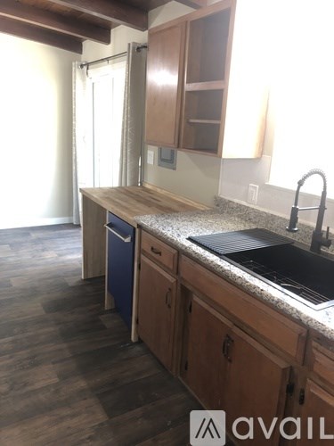 A kitchen with wooden cabinets and a granite countertop.