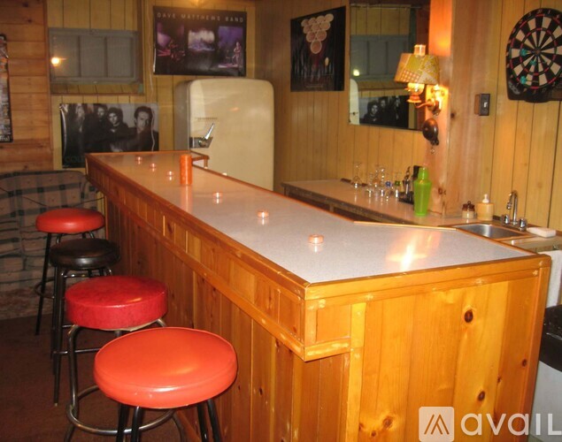 A bar with a white counter and red stools.