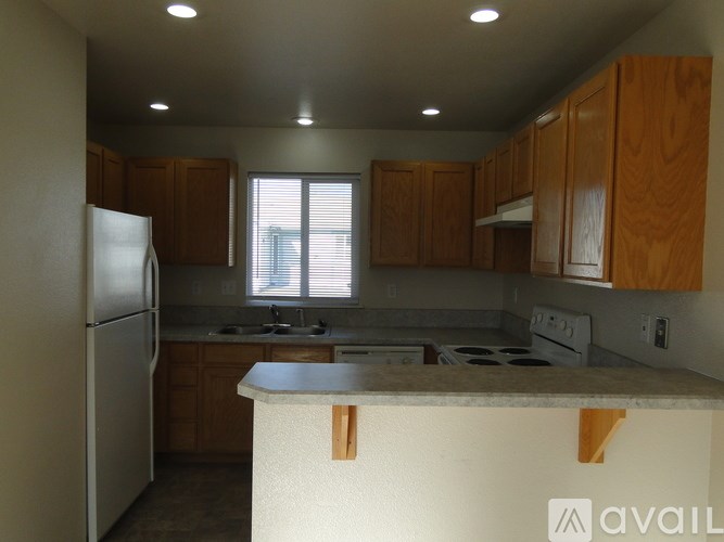 A kitchen with wooden cabinets and a white refrigerator.