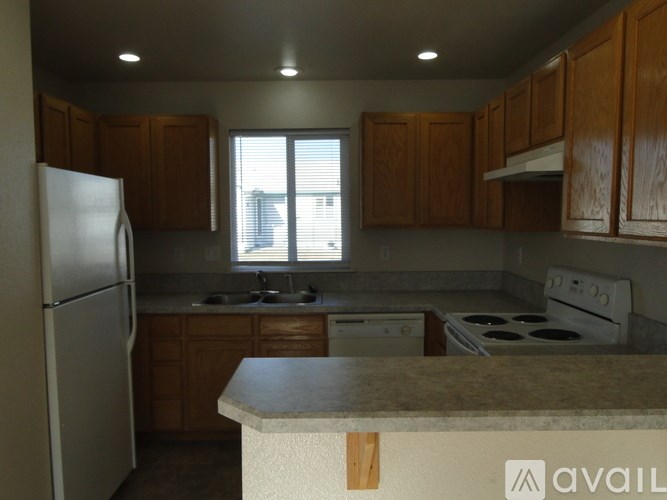 A kitchen with wooden cabinets and a white refrigerator.