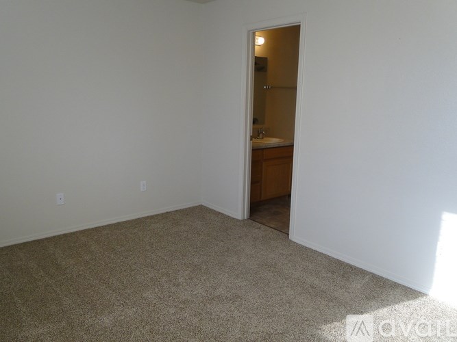 A room with a carpeted floor and a doorway leading to another room.