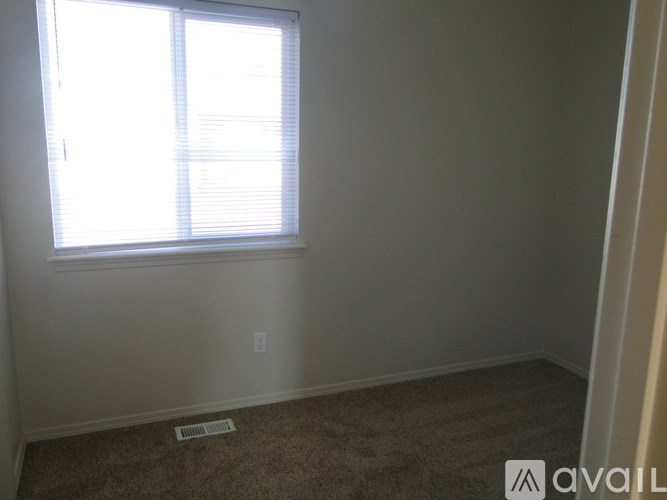 A room with a window and a carpet on the floor.