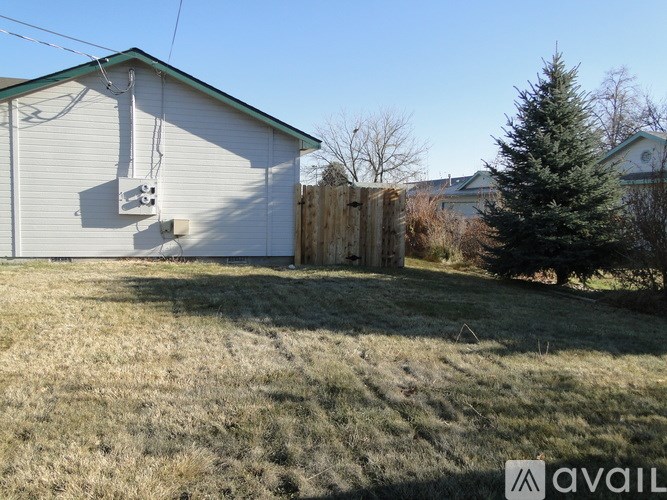 A house with a white garage door and a wooden fence in front of it.