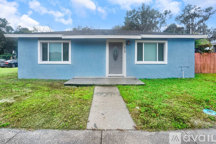 A blue house with a grey door and windows.
