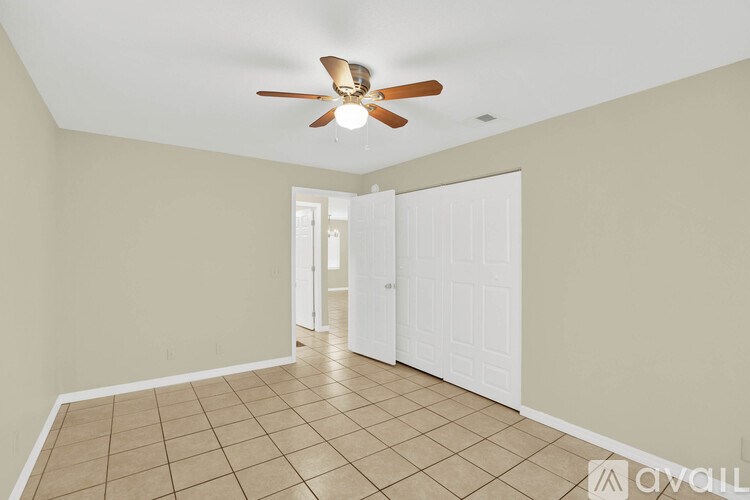 A room with a ceiling fan and tile flooring.