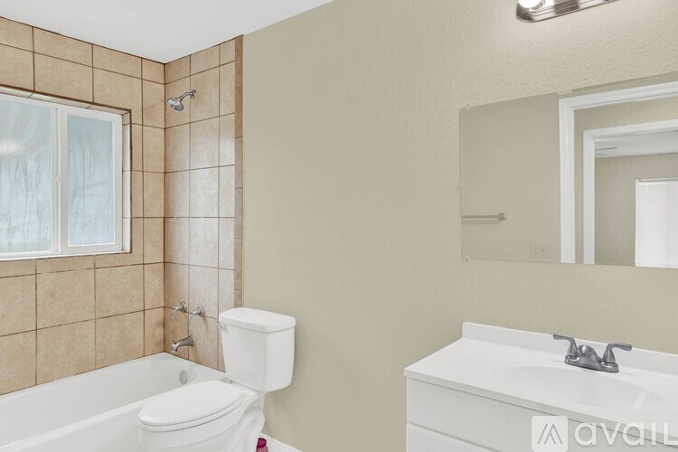 A bathroom with a white toilet, a white sink, and a bathtub with a shower head.