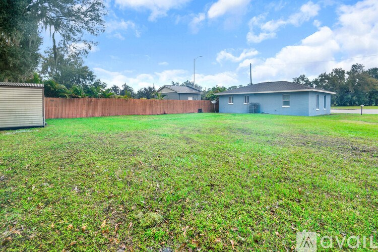 A backyard with a fence and a house in the background.