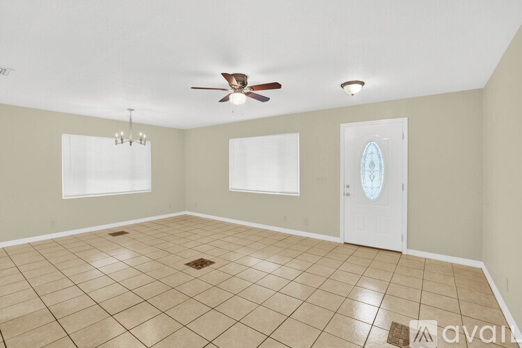 A room with a ceiling fan and a door.