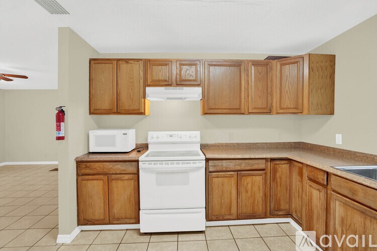 A kitchen with wooden cabinets and a white stove top oven.