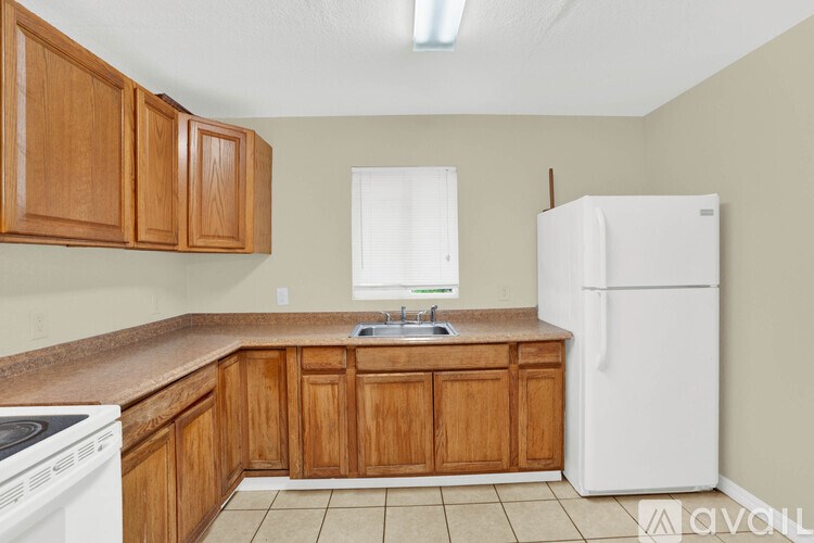 A kitchen with wooden cabinets and a white refrigerator.