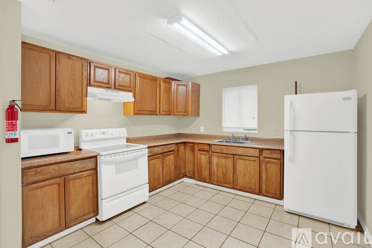 A kitchen with white appliances and wooden cabinets.