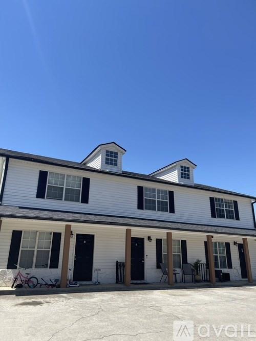 A white house with black shutters and a black door.