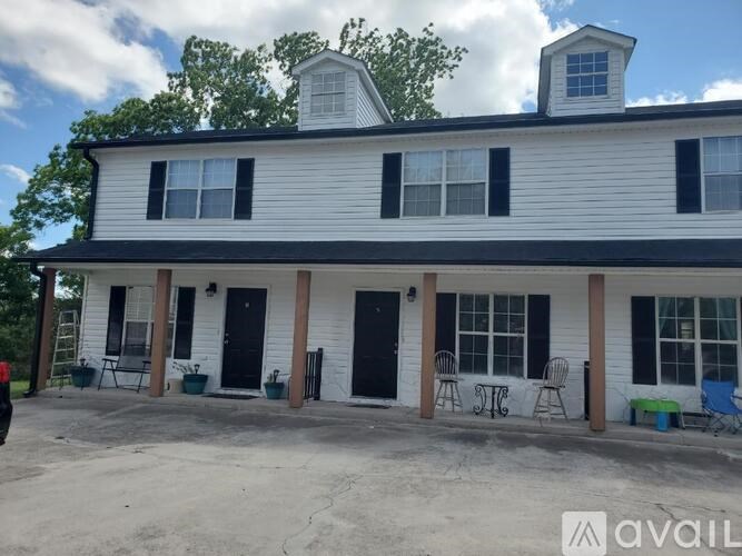 A white house with black shutters and a black door.