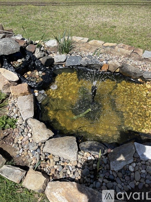 A small pond with rocks and water flowing into it.