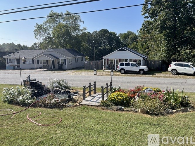 A house with a garden in front and a caravan in the background.