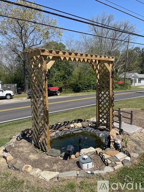 A wooden structure with a pond in front of it.