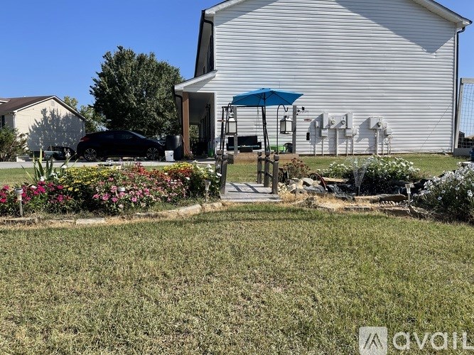 A house with a blue umbrella and a car parked in front.