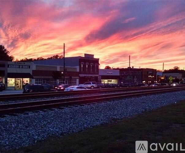 A train station with a vibrant sunset in the background.