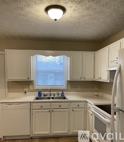 A kitchen with white cabinets and appliances.