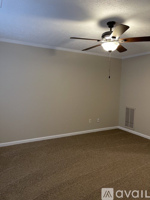 A room with a ceiling fan and carpeted floor.