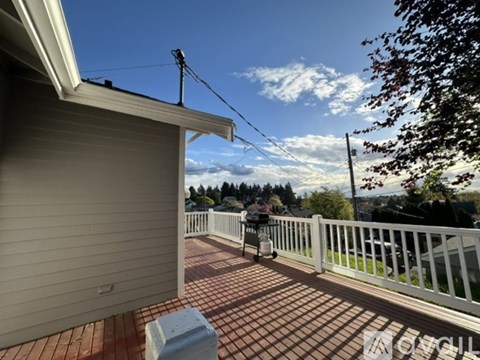 A patio with a white railing and a table with chairs is shown.