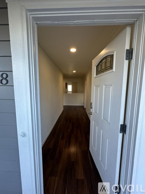 A hallway with a white door and a number 8 on the wall.