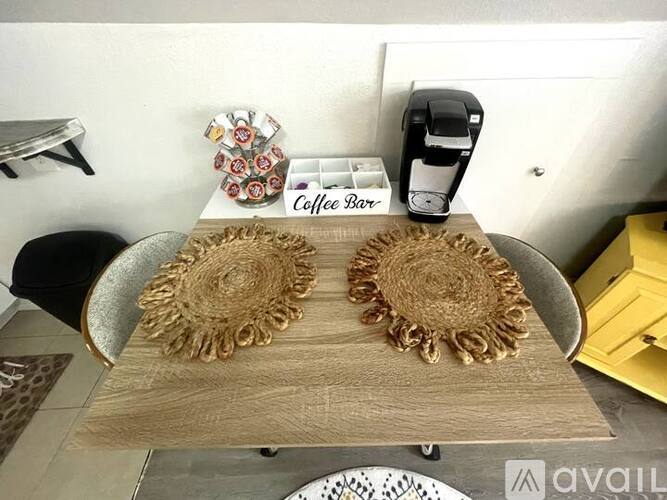 A coffee bar with a coffee machine and two decorative items on the table.