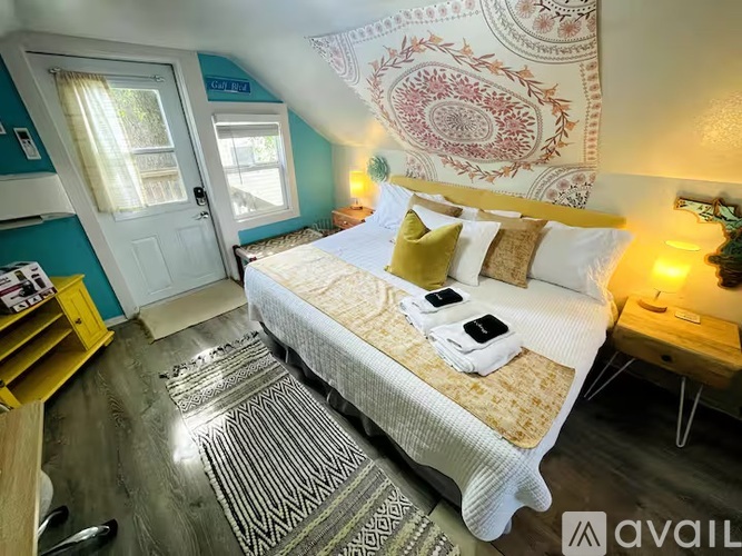 A bedroom with a bed, a window, and a rug.