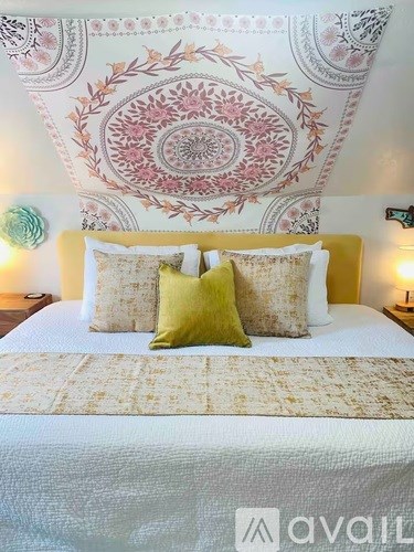 A bed with a yellow headboard and two green pillows.