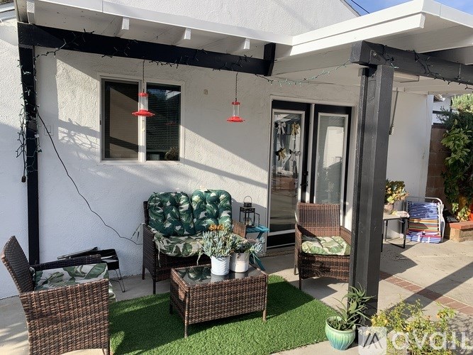 A patio with a chair, a table, and a couch.