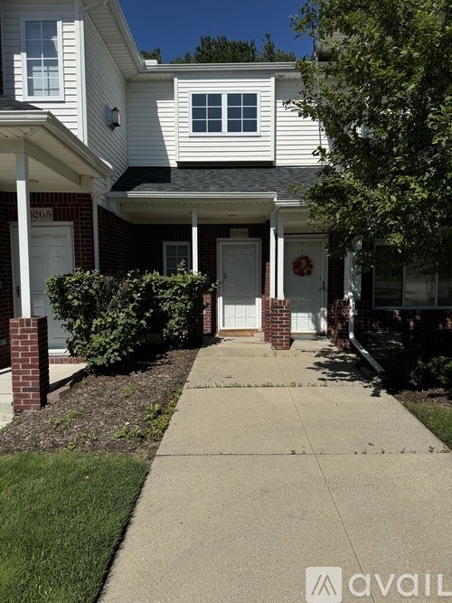 A white house with a porch and a wreath on the door.
