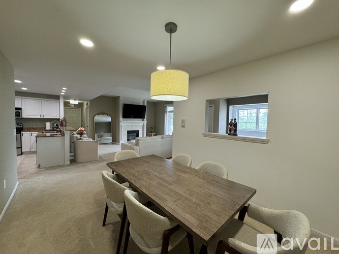 A dining room with a wooden table and chairs.