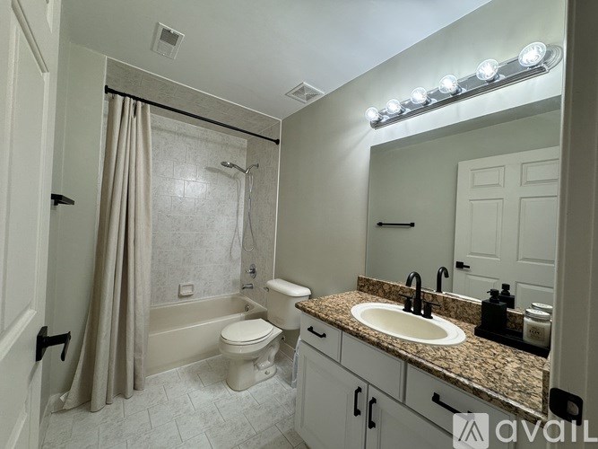 A bathroom with a toilet, sink, and shower.