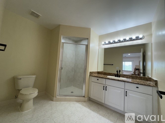 A bathroom with a toilet, sink, and shower.