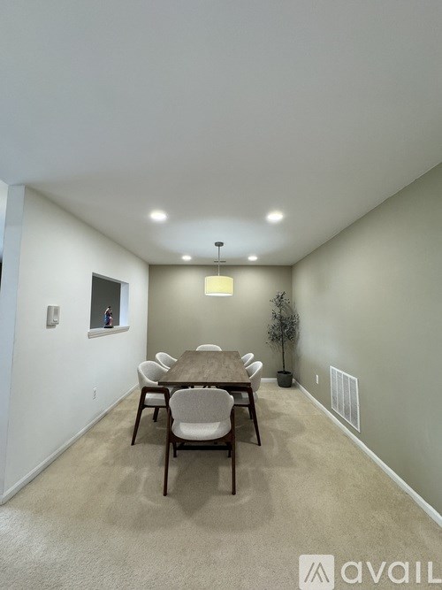 A dining room with a table and chairs.
