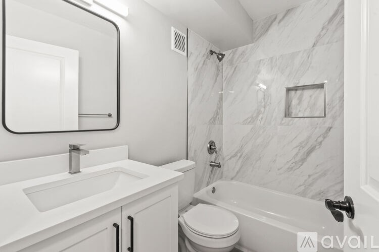 A bathroom with a marble wall and a white toilet.