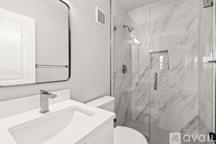 A bathroom with a marble sink and shower.