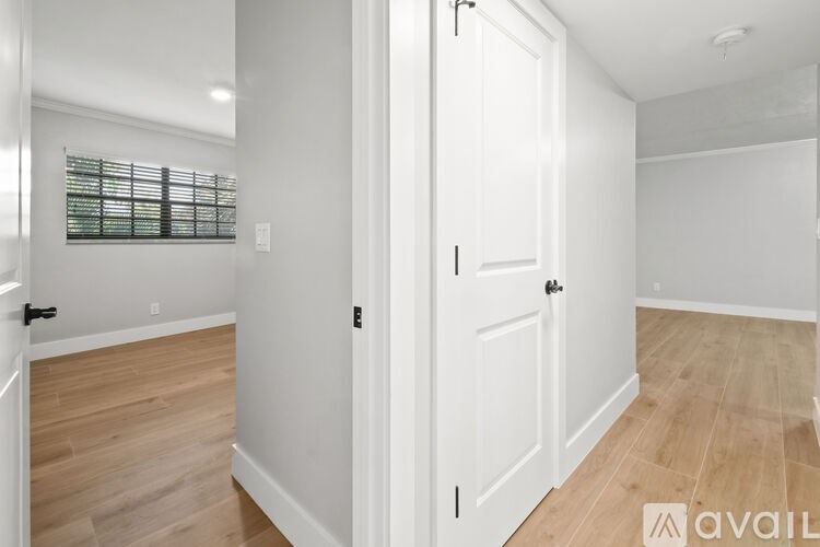 A white door is in a room with wooden floors.