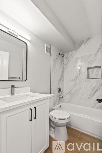 A white bathroom with a toilet, sink, and tub.