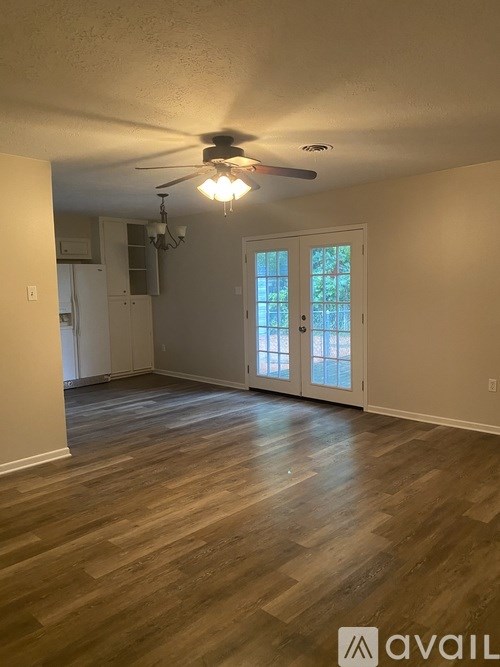 A room with wooden flooring and a ceiling fan.