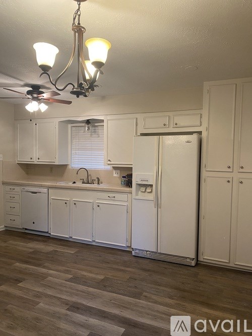 A kitchen with white cabinets and a ceiling fan.