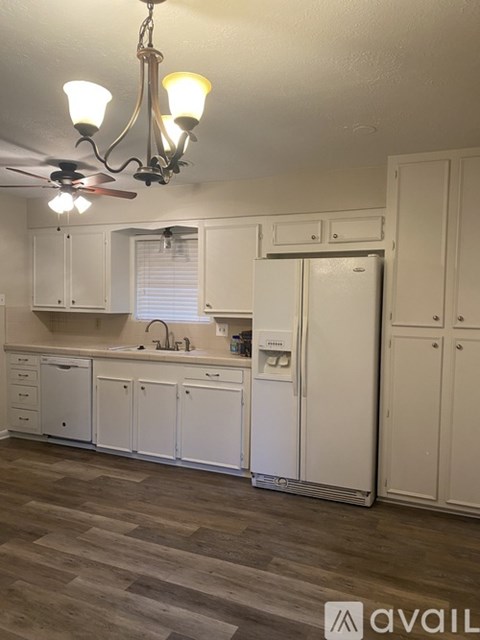 A kitchen with white cabinets and a ceiling fan.