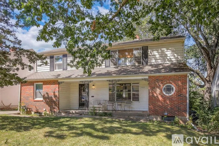A house with a red brick chimney and a white garage door is for sale.