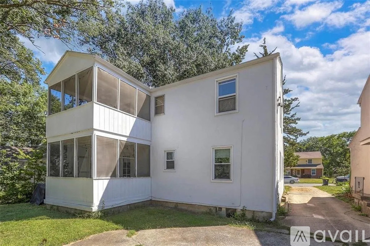 A white two-story house with a balcony on the upper floor.