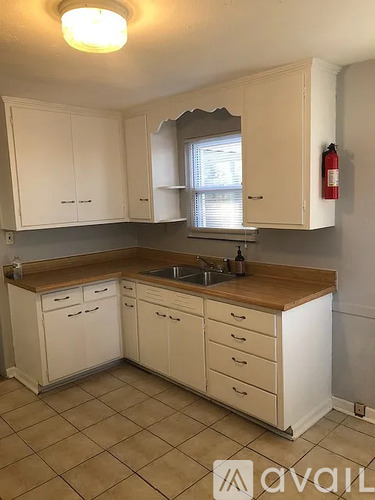 A kitchen with white cabinets and a wooden countertop.
