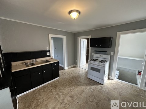A kitchen with black cabinets and a white stove top oven.